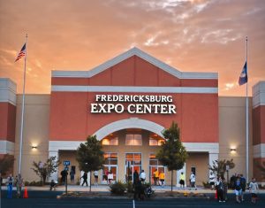Front view of Fredericksburg Expo Center with people entering and a sunset